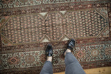 Distressed Kurdish Hamadan rug corner with mahi-mahi spandrel and floral palmette border.