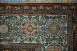 Distressed Kurdish Hamadan rug corner, with palmette border and muted floral field patterns.