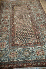 Boteh motif, mahi-mahi spandrels, and floral palmette border on a distressed Kurdish Hamadan rug.