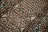 Detail of vintage distressed Kurdish Hamadan rug: time-softened tones highlight boteh and palmette patterns.