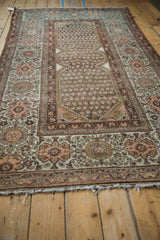 Overall distressed texture showcasing muted palmette borders and boteh patterns.