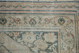 Distressed antique Doroksh rug border with blush wavy bands and dusty teal vines.