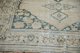 Distressed ivory field, dusty teal curvilinear patterns, antique Doroksh rug corner.