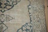 Distressed antique Doroksh rug border showing scrolling vine with ivory and dusty teal.