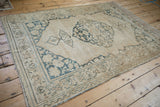 Faded ivory and dusty teal vine motifs on the distressed border of an antique Doroksh rug.