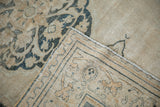 Distressed antique Doroksh rug, folded, showing faded ivory and dusty teal motifs with woven back.