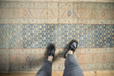 A vintage Malayer runner showing its abrashed blue field and distressed low-pile texture.
