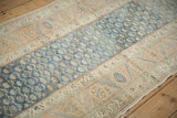 Angled detail of the vintage Malayer runner's low pile, contrasting the abrashed blue field with sandalwood borders.