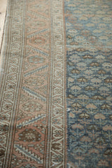 Detail of the vintage Malayer rug's abrashed field and intricate sandalwood and blue border.