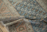 A fold in the vintage Malayer rug highlights its soft, low pile and abrashed blue and sandalwood design.