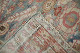 A corner of the antique Karaja carpet is folded to show its hand-knotted foundation and distressed pile.