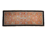 Antique Nichols Art Deco sampler rug with scrolling lotus flowers on a terracotta field, framed by a wide charcoal border.