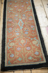 Angled perspective of an antique Nichols Art Deco rug showing its scrolling vine pattern.