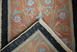 Folded corner of an antique Art Deco rug showing its hand-knotted back and original side cord.