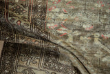 Folded vintage Hamadan rug section, highlighting distressed pile texture and muted beige, brown tones.