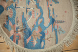 The neatly secured edge and added machine fringe on a round Art Deco pictorial rug.