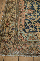 Detailed view of a tattered side and worn floral border on an antique Persian Malayer rug.