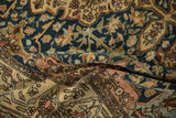 The soft, flexible handle of an antique Malayer rug, revealing its low pile and floral motifs.