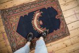 Antique Persian saddle cover with an asymmetric form and striking central horn motif.