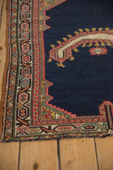 Close-up of the geometric corner spandrel and multi-layered border on an antique Persian rug.