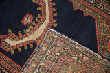 Folded corner of an antique Persian saddle cover revealing the reverse weave and front pile with foundation wear.