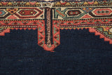 Detail of a hand-stitched cord and ruby red geometric spandrel on an antique Persian rug.
