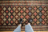 Antique Kurdish Malayer runner's geometric lattice with ruby red, charcoal, and meandering borders.
