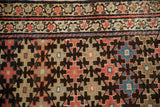 Kurdish Malayer runner's geometric patterns and double borders in ruby red, charcoal, and blue.