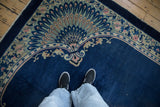Antique Chinese Art Deco rug corner displaying a peacock motif in cobalt blue and dusty rose.