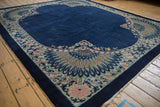 Corner of an Antique Art Deco carpet showing cobalt blue field and a vibrant peacock design.
