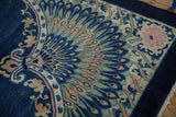 Antique Chinese Art Deco carpet corner showing peacock motif, scrolling tendrils, and fringe.