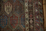 Detailed view of the soft wool pile showing time-softened knot heads and polychromatic boteh motifs.