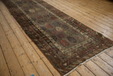 Angled side view of an antique Kurdish runner showing the rich patina and staggered boteh design.
