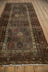 Angled view of an antique Hamadan runner showing the stepped rows of polychromatic botehs.