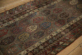 Stepped rows of polychromatic botehs and fine wool texture on an antique Kurdish runner.