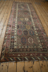 Perspective view of a long antique Kurdish runner with intricate polychromatic boteh motifs.