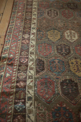 Lustrous wool pile of an antique Kurdish runner with aubergine and terracotta boteh designs.