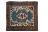 Vintage Bakshaish square rug with a sapphire blue shield medallion, beige field, and a dark aubergine pomegranate border.