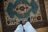 Overhead view of a vintage Bakshaish rug's stylized medallion on an aquatic blue field.