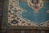 Intricate pomegranate border alongside the dusty sapphire blue field of a collector Persian Bakshaish rug.