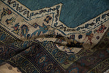 Textured weave and intricate pomegranate border on a folded vintage Bakshaish collector rug.