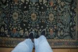 Intricate shadow medallions and vines on a vintage Lilihan rug with even wear over its charcoal navy field.