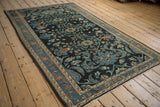 Full profile of a distressed vintage Lilihan rug with intricate teal and copper shadow medallions.