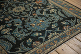 Corner view of the fine Lilihan rug showing even wear and scrolled leaves in dusty teal and beige.