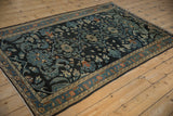 A vintage distressed Lilihan rug from an angle, highlighting the soft wear and intricate vine patterns.