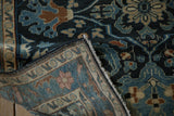 A folded corner of the vintage Lilihan rug reveals its hand-knotted back and intact side cord.