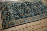 Angled perspective of the distressed Lilihan rug's charcoal navy field and intricate pattern.