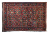 Vintage Sarouk rug with an intricate Herati design covering a field of cherry red, navy blue, and teal.