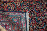 Intricate blossom palmette border and ivory fringe of a hand-knotted vintage Sarouk rug.