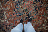 Vintage Gorevan rug featuring geometric buds and blossoms in brick red and sapphire blue.